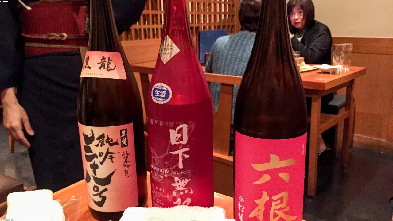 Standing drinkers at a kakuuchi liquor-store bar counter in Kokura's Uomachi district